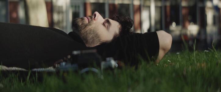 男人躺在草地上闭眼休息