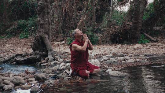 男人在溪流边祈祷