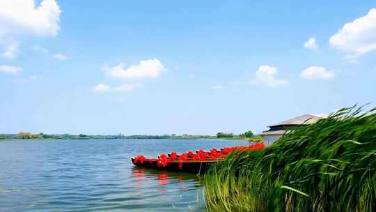 湖边停靠装饰红色绸带的船只
