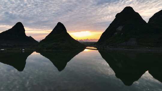 夕阳下山间的湖和穿过山间的高速公路高架桥