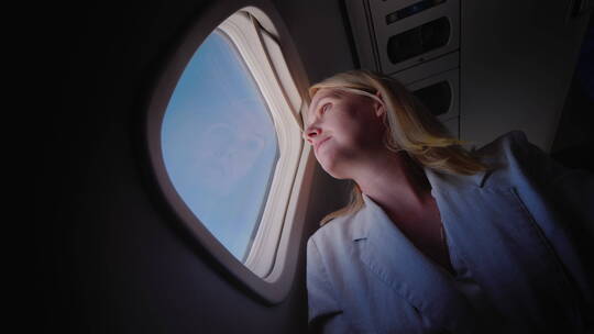 妇女乘坐飞机向窗外望去