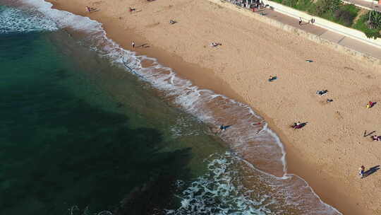空中无人机拍摄冲浪者滑板在海海滩埃斯托里
