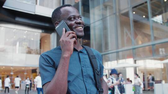 黑人青年在成都街头开心打电话交谈事业成功