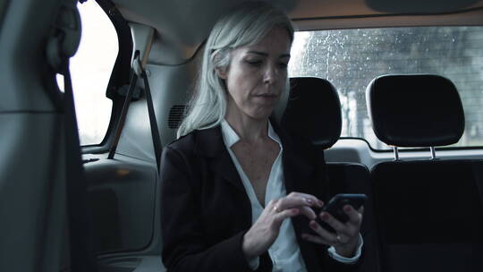坐在汽车里使用手机的女人