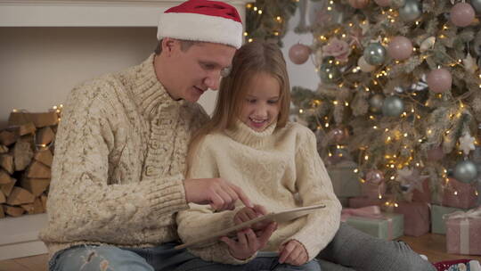 圣诞节父亲陪女儿玩平板