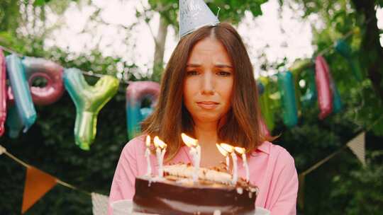 一个戴着派对帽的悲伤女人独自站在节日生日