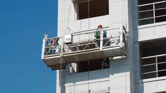 工人们正在楼房上施工建设