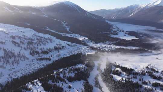 航拍新疆冬季喀纳斯河流晨雾雪山森林雪景