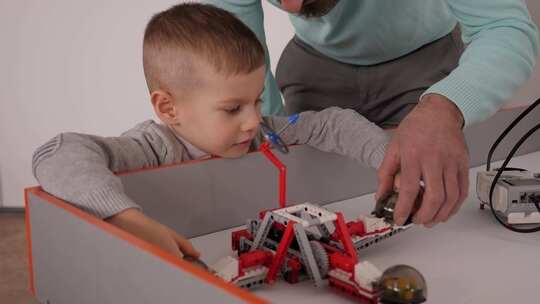 由建筑套件组装而成的年轻父子控制机器人