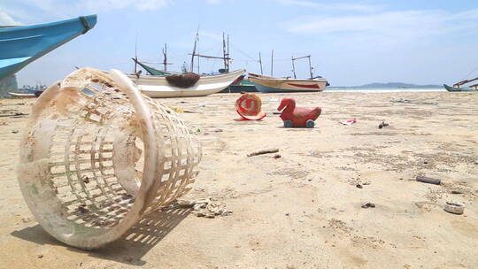 斯里兰卡威利加马——2014年3月：垃圾被冲上海岸，在海滩上的木制钓鱼吹嘘前。