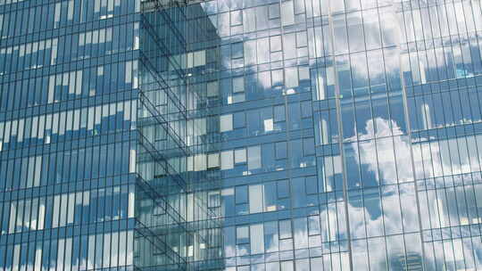 玻璃摩天大楼的时间流逝，云彩反射在办公室窗户上