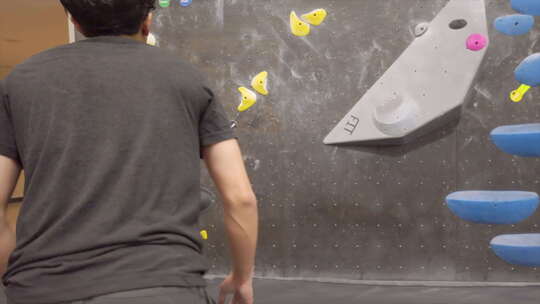 亚洲登山者家伙在健身房爬上室外抱石墙视频素材模板下载