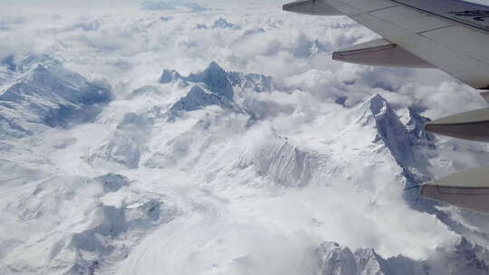 飞机在雪山高原和云海上飞行