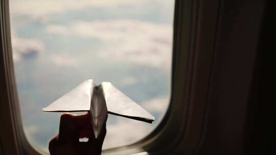 孩子在飞机窗手拿纸飞机