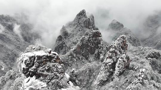 云雾缭绕的雪山及山间小屋景观