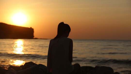 山东烟台夕阳落日下，大海边的女孩背影