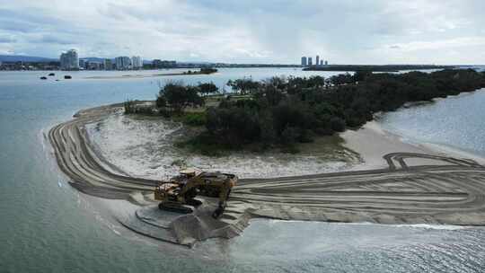 靠近城市天际线的沿海复兴项目中的大型机械砂。全景d
