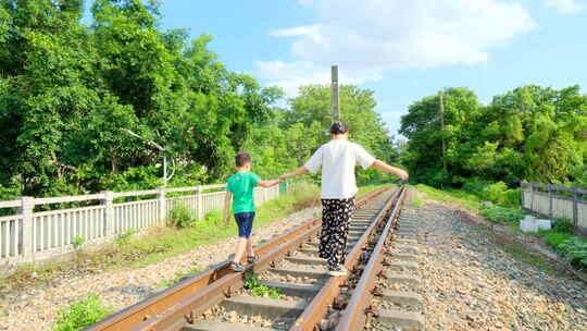 母子 母爱 妈妈带小孩走在铁路上