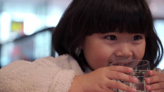 在餐厅喝水的亚洲女孩视频素材模板下载