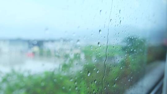 雨水滴在行驶中的高铁动车窗外