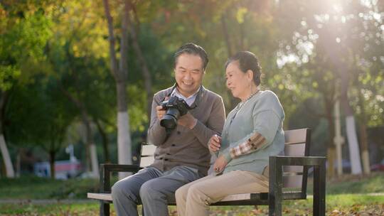 退休老年夫妻旅游在公园内拍照