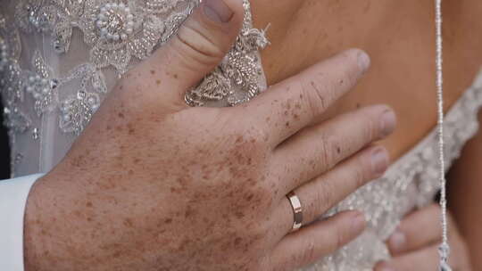 新郎与结婚戒指笔触在婚礼上打开妻子的背部