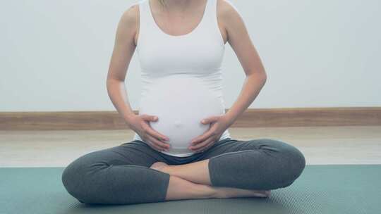 孕妇妈妈抚摸着自己的肚子期待宝宝出生