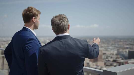 两个商人在高层阳台上聊天和指指点点