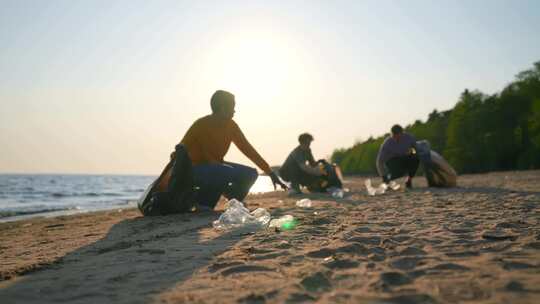 人民志愿者在海岸捡垃圾清洁沙滩的人在海洋