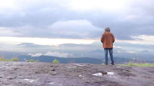 年轻人站在悬崖上欣赏大自然。