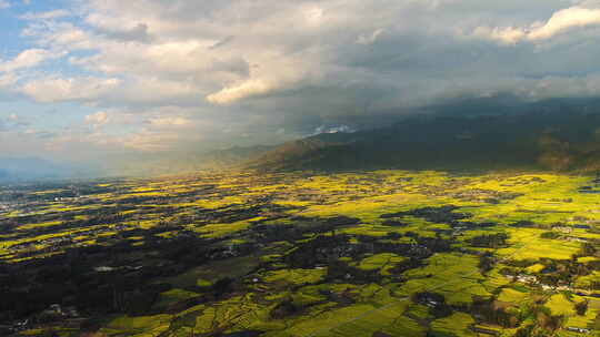 夕阳日落 高山下的乡村金黄油菜花田