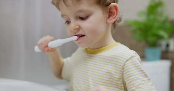 小男孩在浴室用电动牙刷刷牙