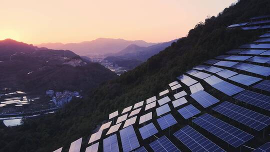 航拍日落时分山上光伏太阳能电池板