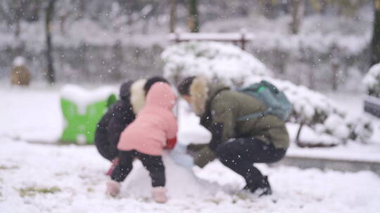 幸福的一家三口在堆雪人