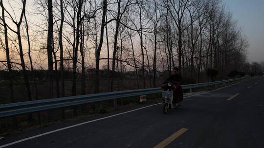 夕阳下乡村公路悠闲汽车电动车田园风光江苏