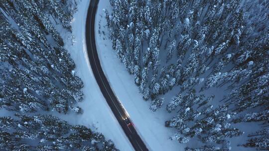 航拍汽车在雪林公路上行驶