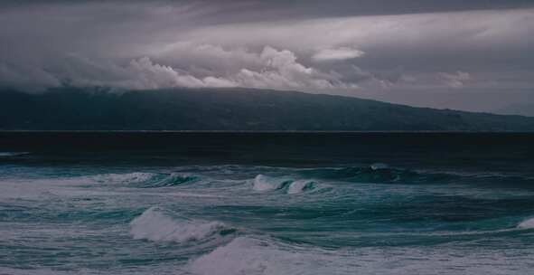 暴风雨的海浪带着暴风雨的云层涌向岸边