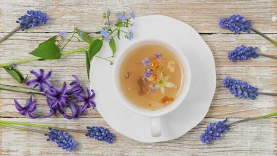 健康凉茶在白色杯子里，里面有药草。天然花
