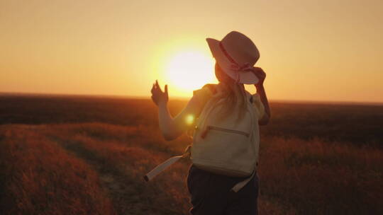 女孩戴着帽子在田野行走