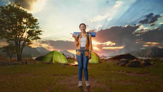 全身的亚洲女性徒步旅行者微笑和指向一边而