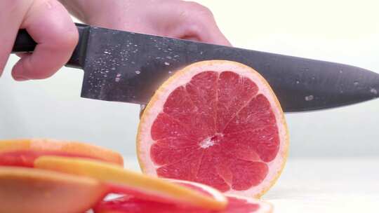 特写用小刀将葡萄柚切成薄片