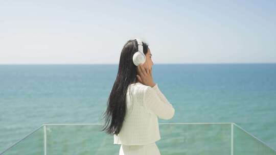 美女海边听音乐享受生活