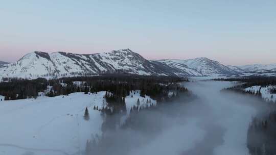 航拍新疆冬季喀纳斯河流晨雾雪山森林雪景