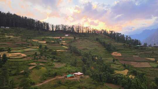 无人机拍摄卡索尔马纳利附近喜马偕尔邦塞恩吉山谷一个小村庄的日落