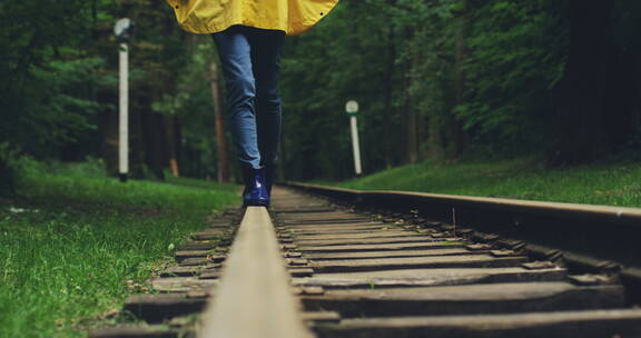 女性在铁路上行走的特写镜头