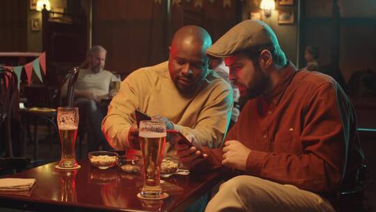 两个男人聚会喝酒看手机