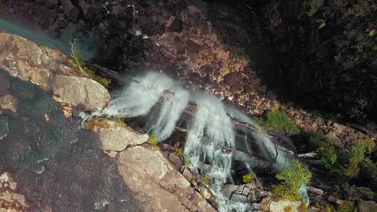 瀑布从高山之上的岩石倾泻到岩石河谷