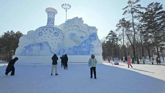 雪地上的大型青花瓷瓶雪雕与游客冬天旅游