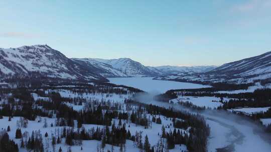 航拍新疆冬季喀纳斯河流晨雾雪山森林雪景