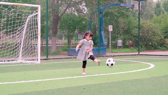 在足球场踢球的中国女童